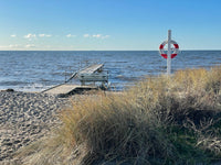 a bench on a beach next to a body of water