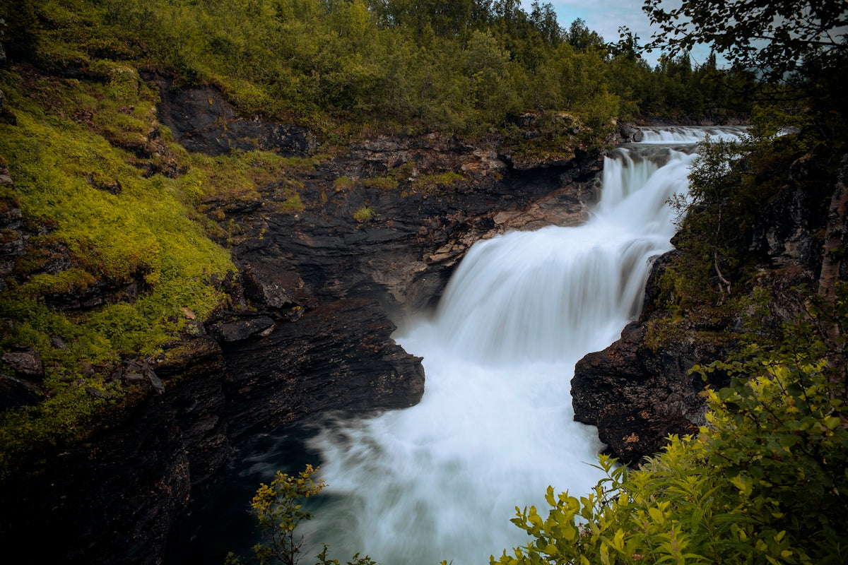 a large waterfall with water cascading down it's sides