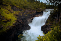 a large waterfall with water cascading down it's sides